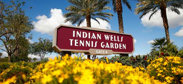 Indian Wells Tennis Gardens sign with yellow flowers in front.